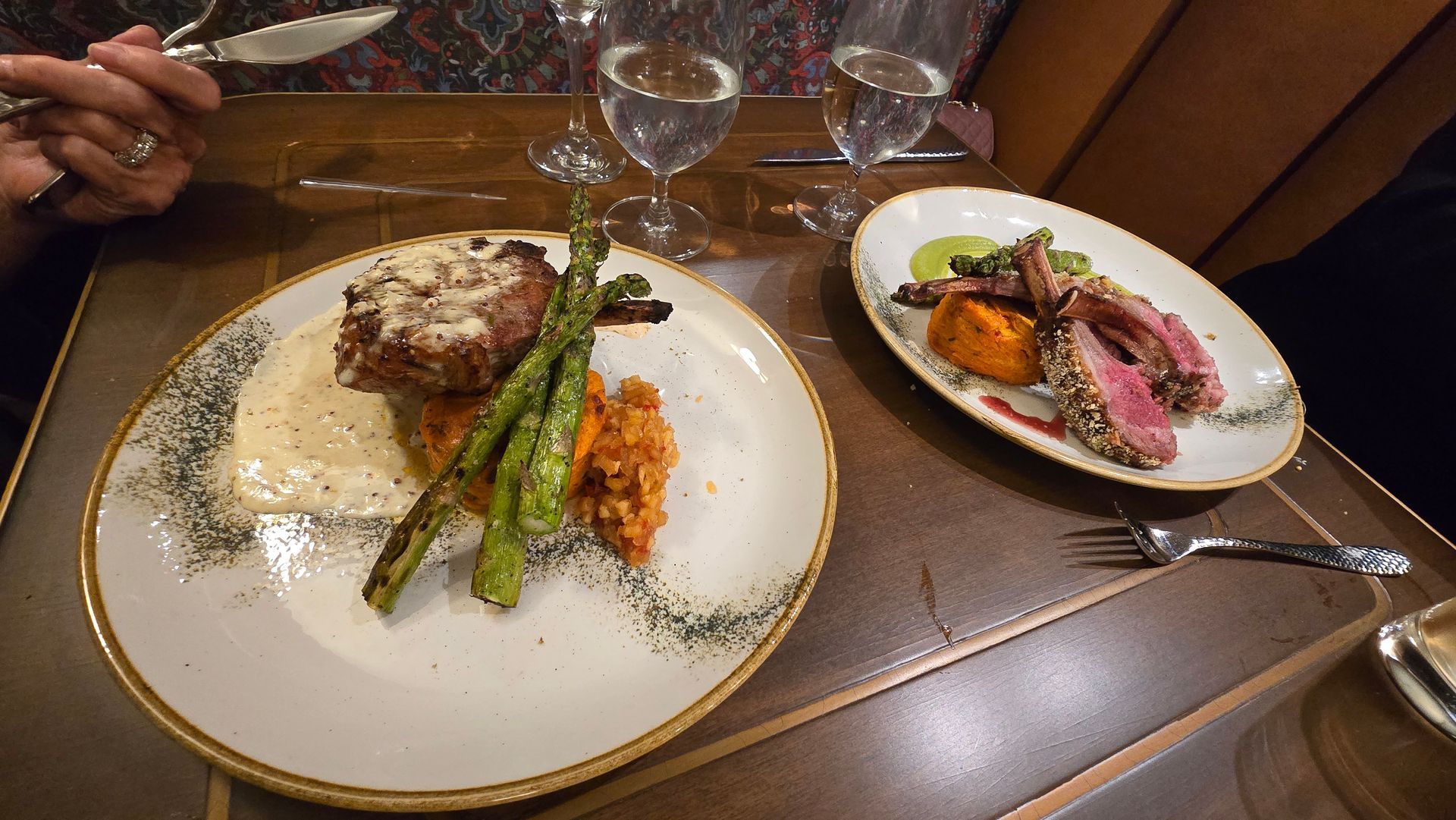 Plated gourmet dinner with steak, asparagus, and vegetables on a restaurant table