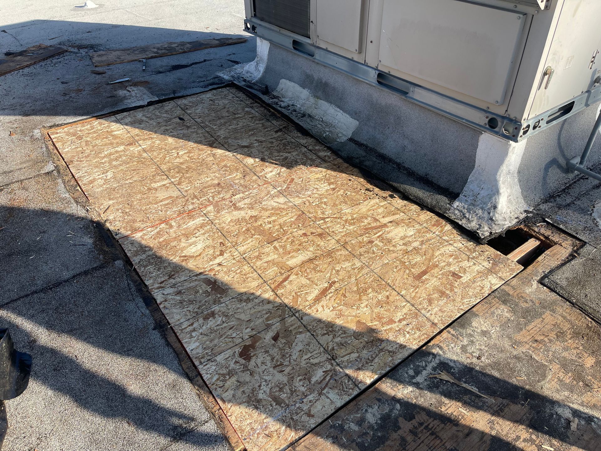 A piece of plywood is sitting on the ground next to a building.