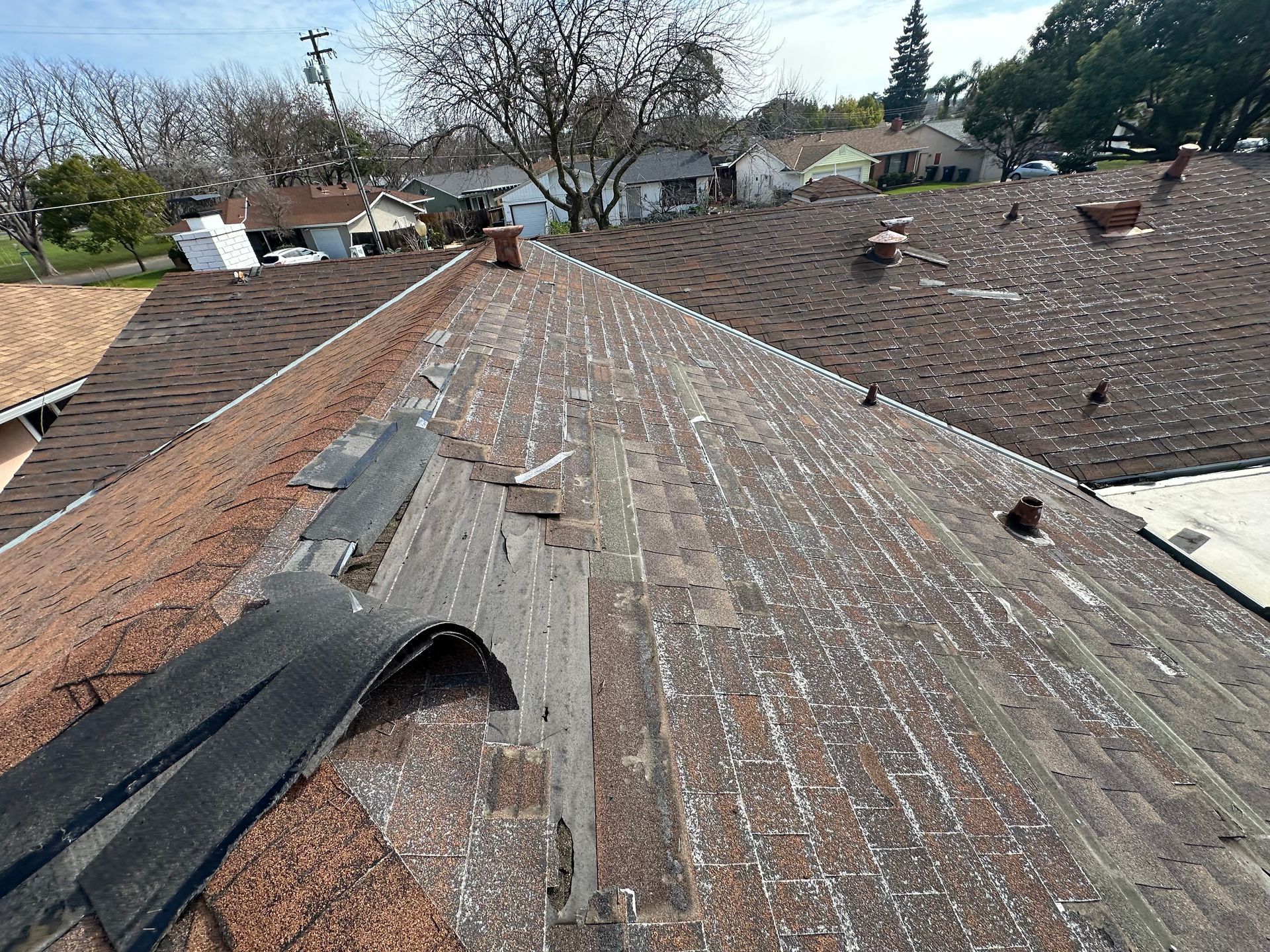 An aerial view of damaged roof shingles.