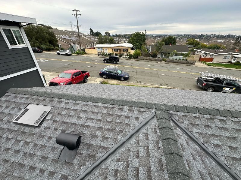 A rooftop view of a residential area with cars parked on the side of the road.