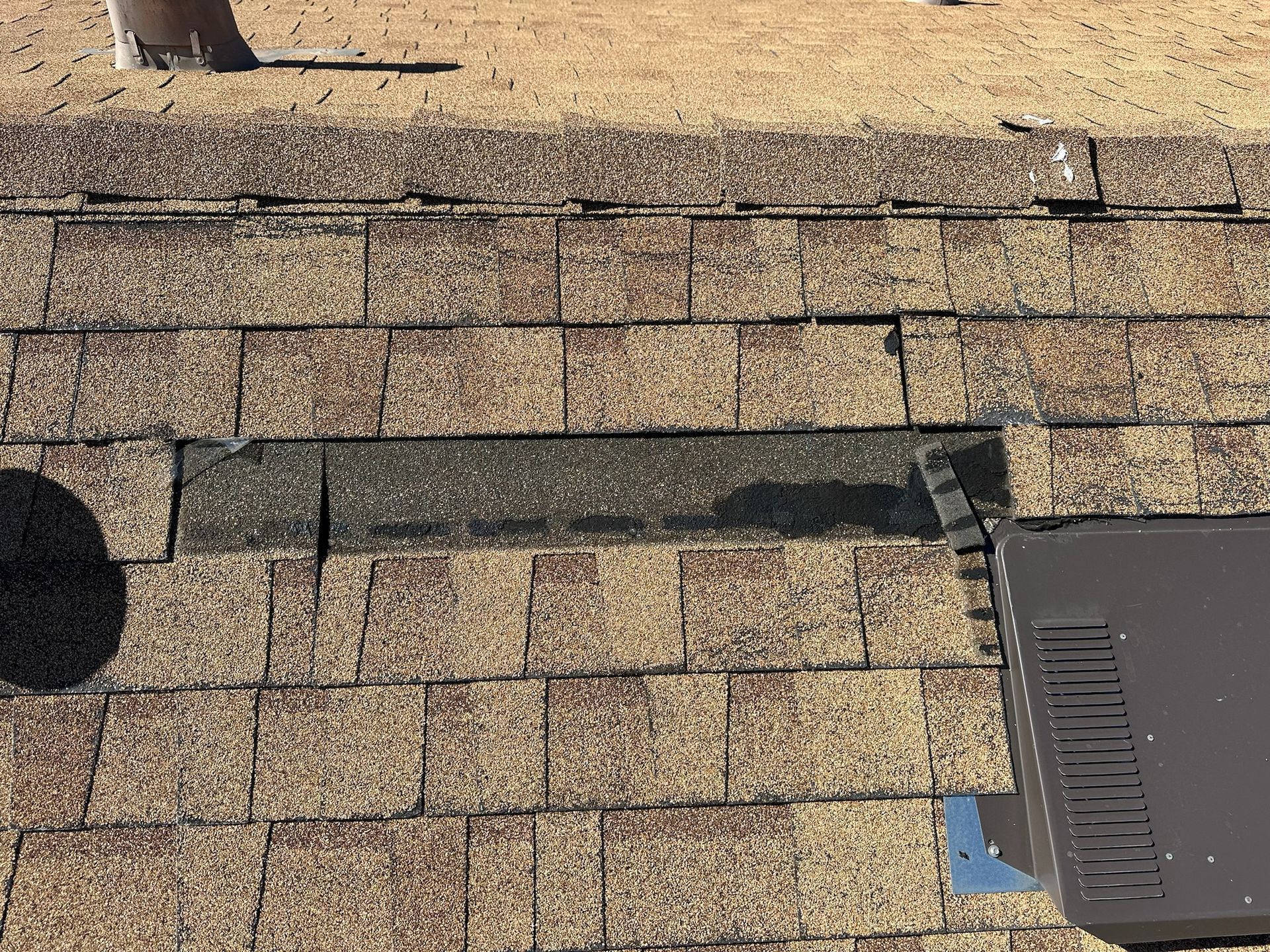 A roof with a lot of shingles on it and a fence in the background.
