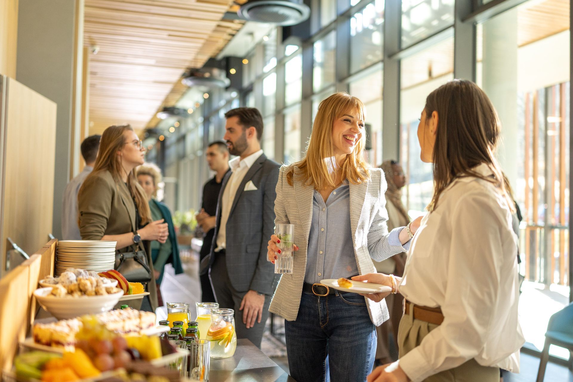 People socializing and eating at a networking event with food and drinks. People socializing and eating at a networking event with food and drinks.