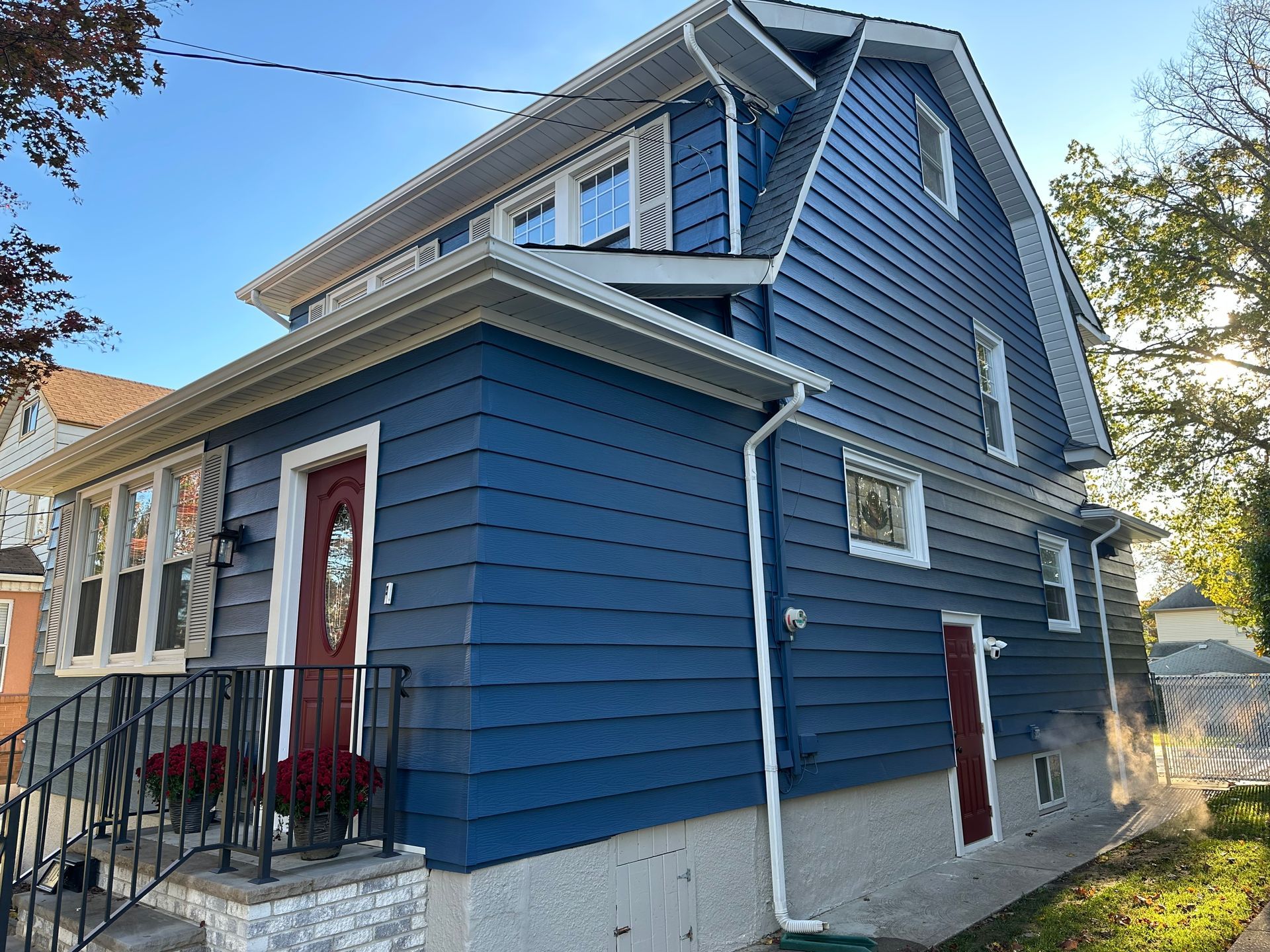 A blue house with a red door and white trim