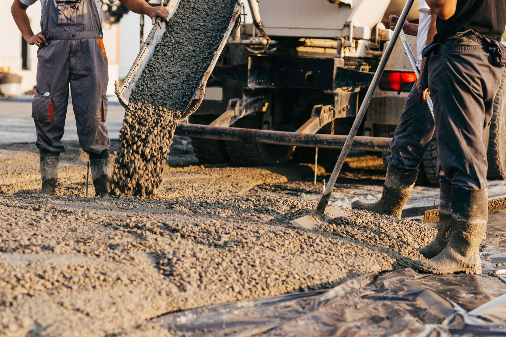 Workers pouring concrete from a truck.