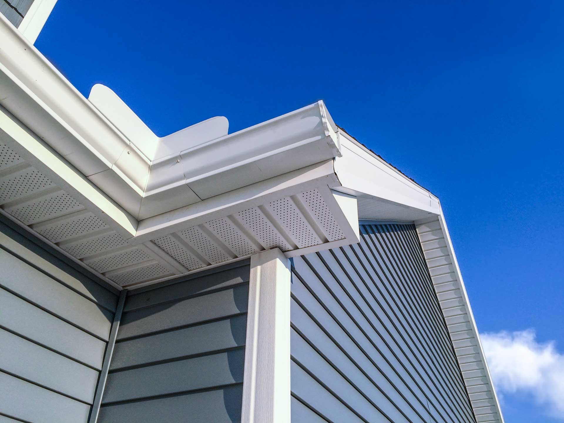 A close up of the roof of a house with a blue sky in the background.