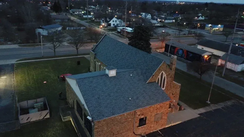 An aerial view of a church in a small town at night.