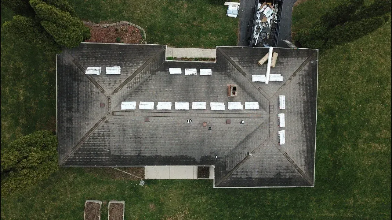 An aerial view of a house with a roof that is being repaired.