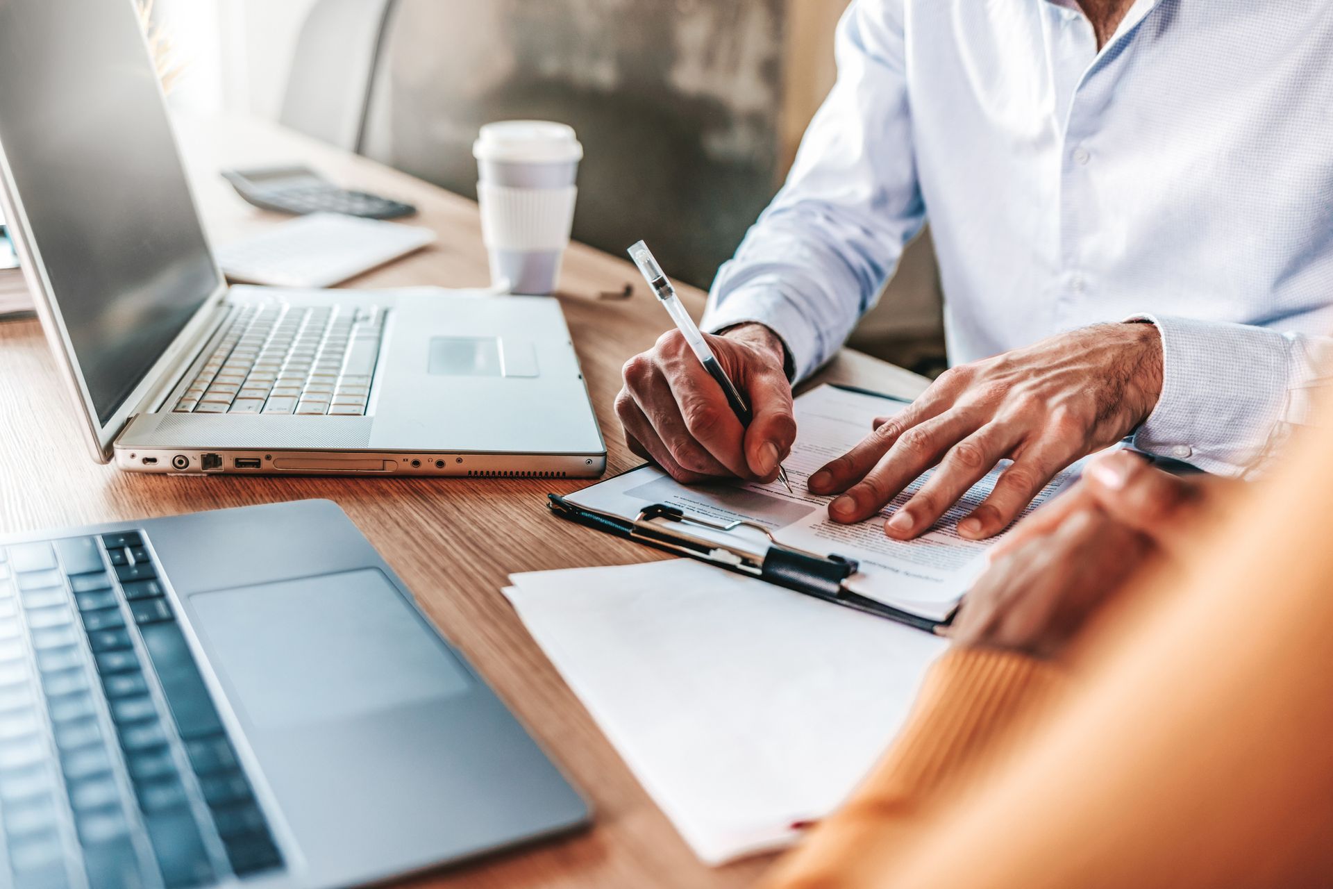 Insurance claims adjuster signing claim documents at an office desk