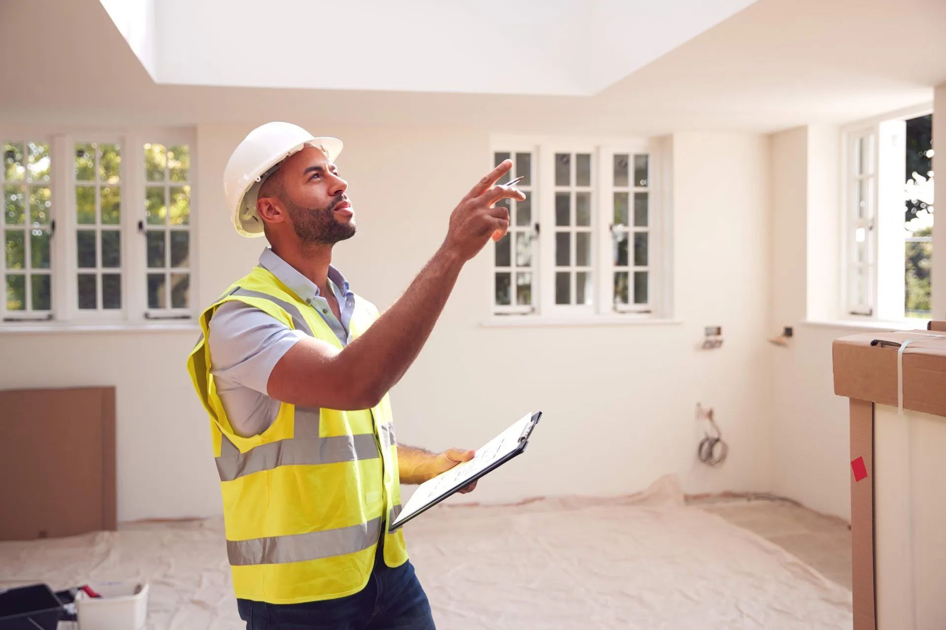 Surveyor conducting a full building survey, inspecting the ceiling in a room