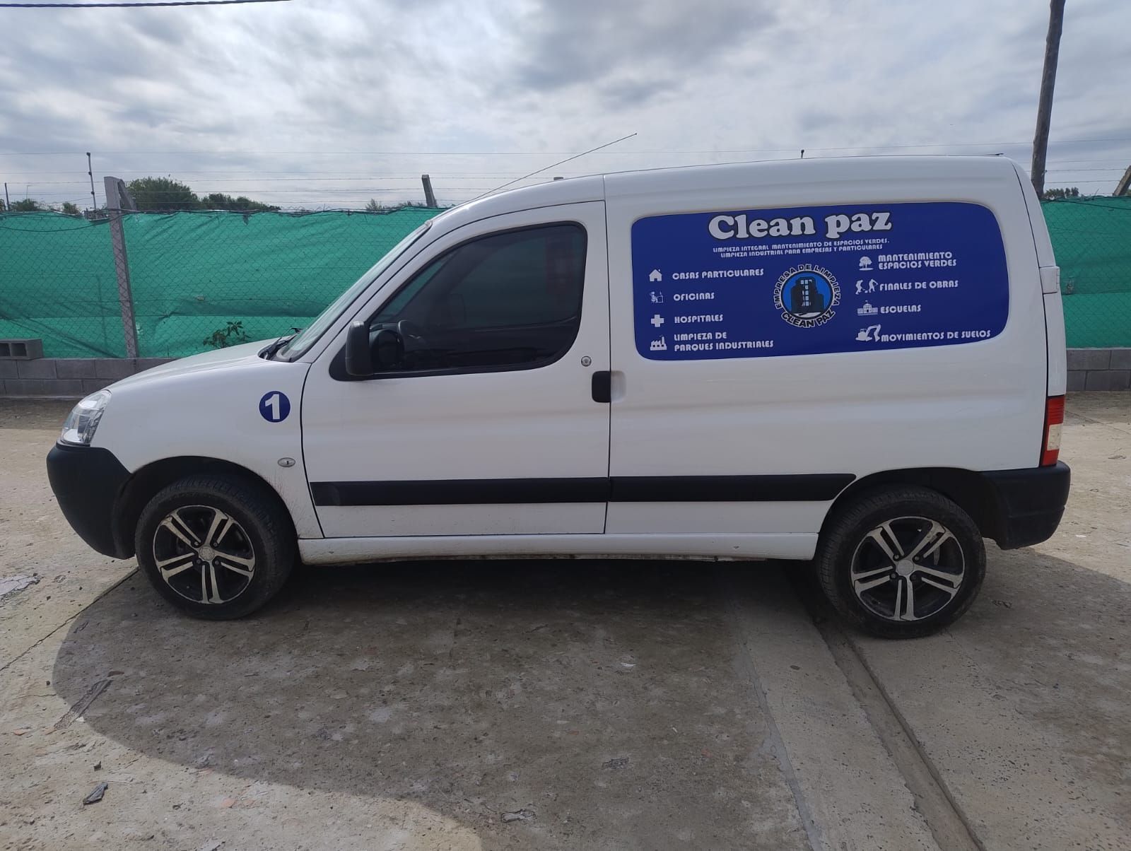 Furgoneta blanca con logo “Clean Paz”, estacionada al aire libre.