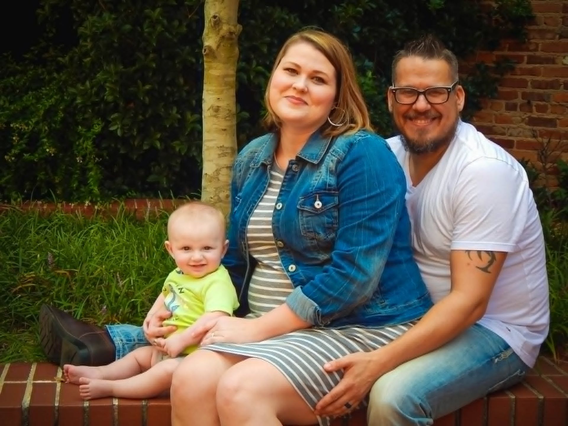 Family standing together outdoors in a grassy field in Newnan, GA during a portrait photo session.