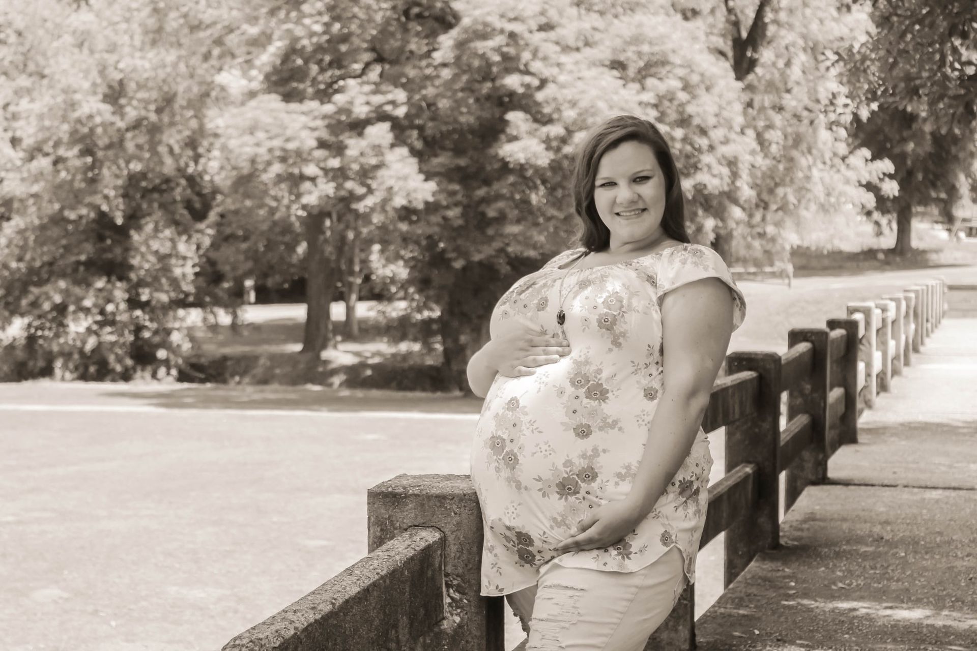 Pregnant woman holding belly on a bridge – Shine Again Photography Newnan GA