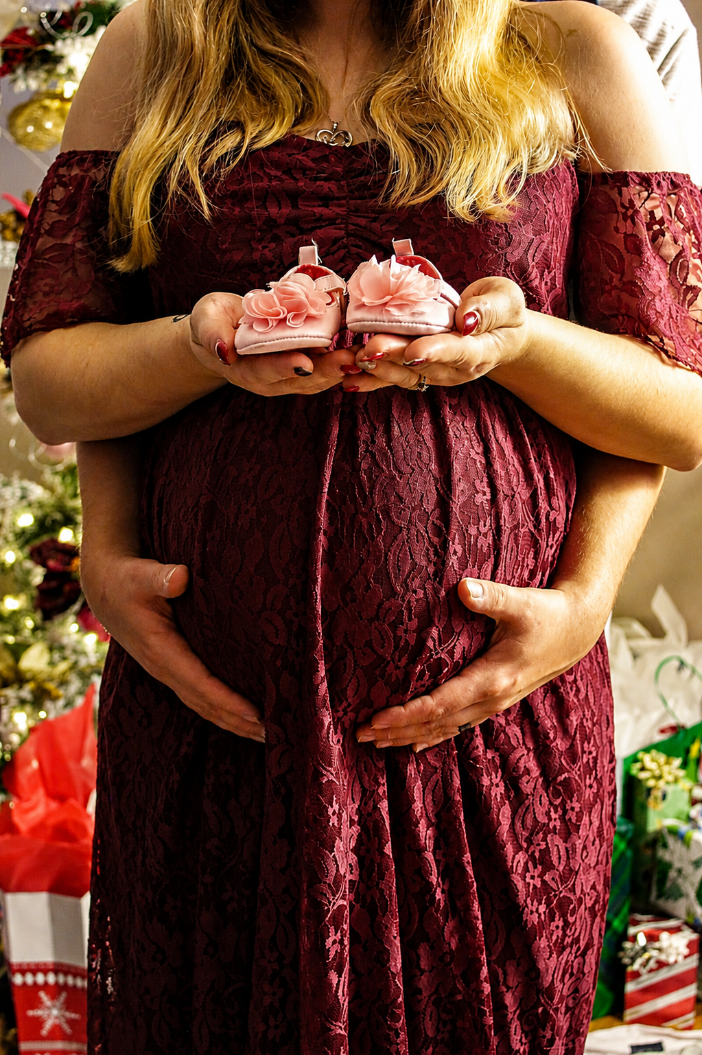 Expectant mother in burgundy dress holding tiny pink baby shoes over baby bump – Shine Again Photography Newnan GA