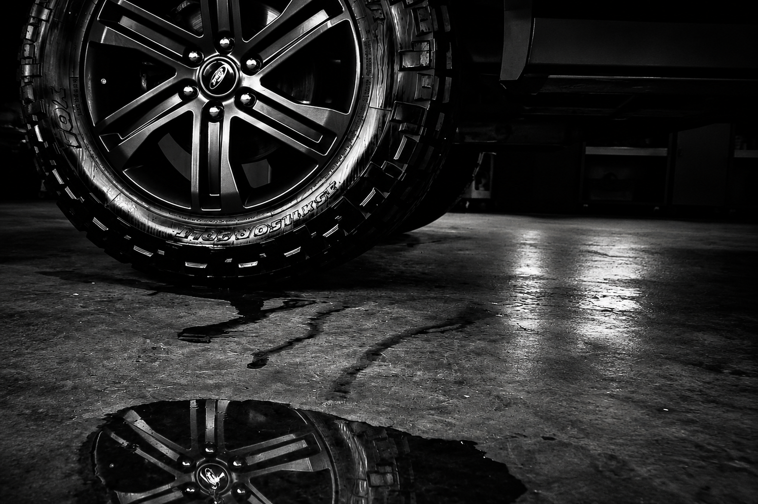 Close-up of Ford truck wheel and tire on wet shop floor – Shine Again Photography Newnan GA
