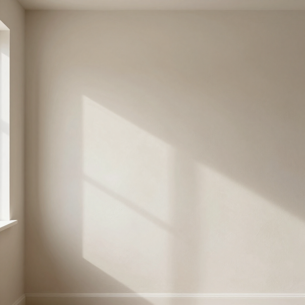 Zonovergoten, lege beige muur met een lichte schaduw van een raam en een glimp van een raamkozijn aan de linkerkant.