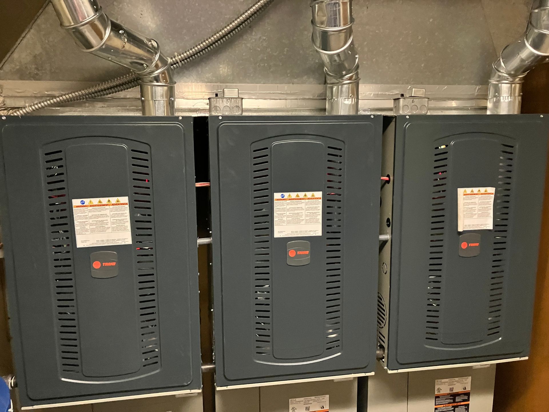 Three air conditioners are sitting on top of each other in a room.