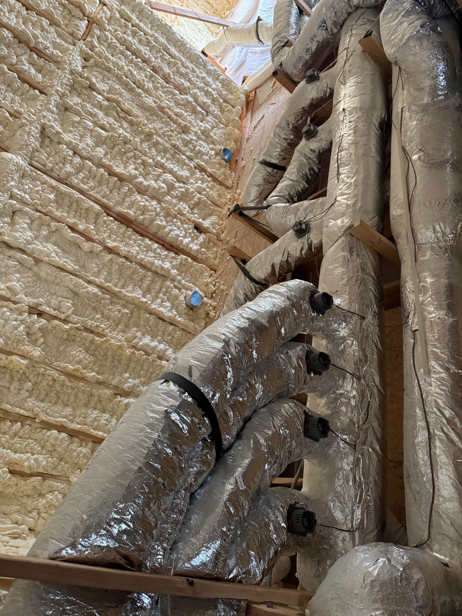 A bunch of pipes are wrapped in plastic and sitting on top of each other.
