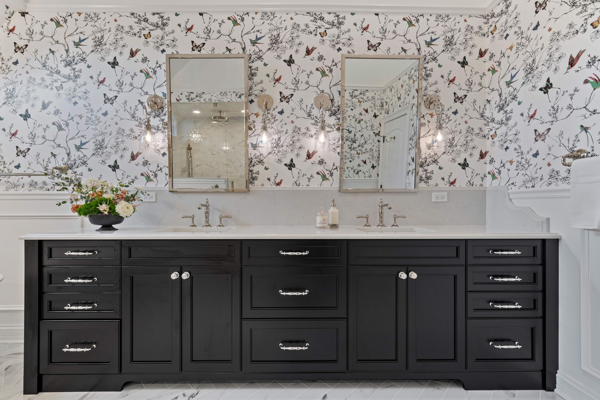 A bathroom with black cabinets and a butterfly wallpaper