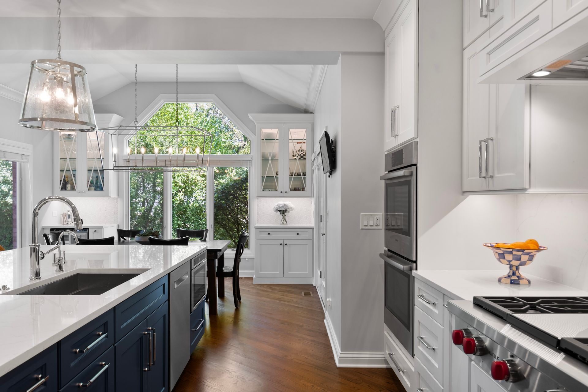 A kitchen with blue cabinets , white cabinets and stainless steel appliances.