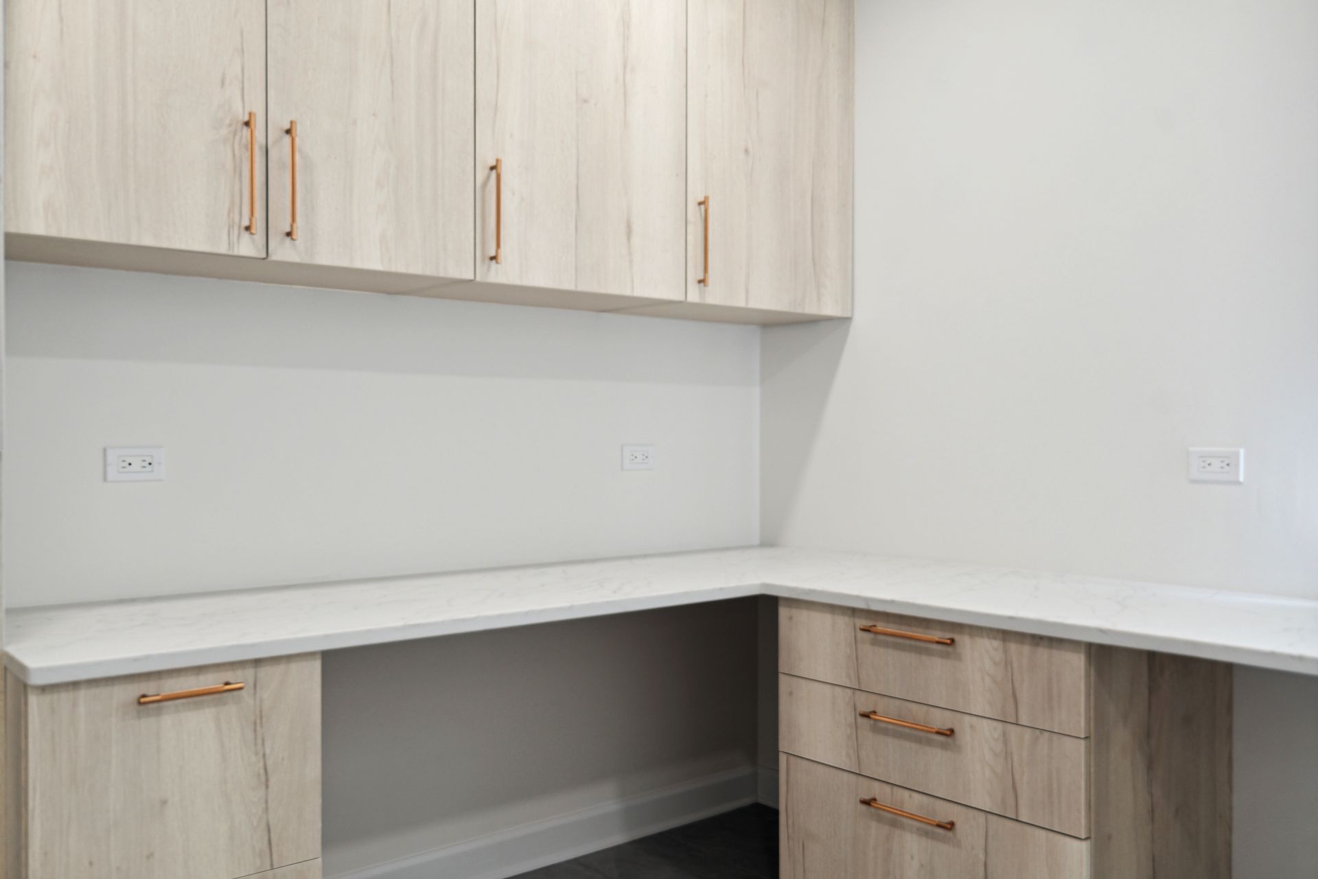 A room with a desk and cabinets in it.