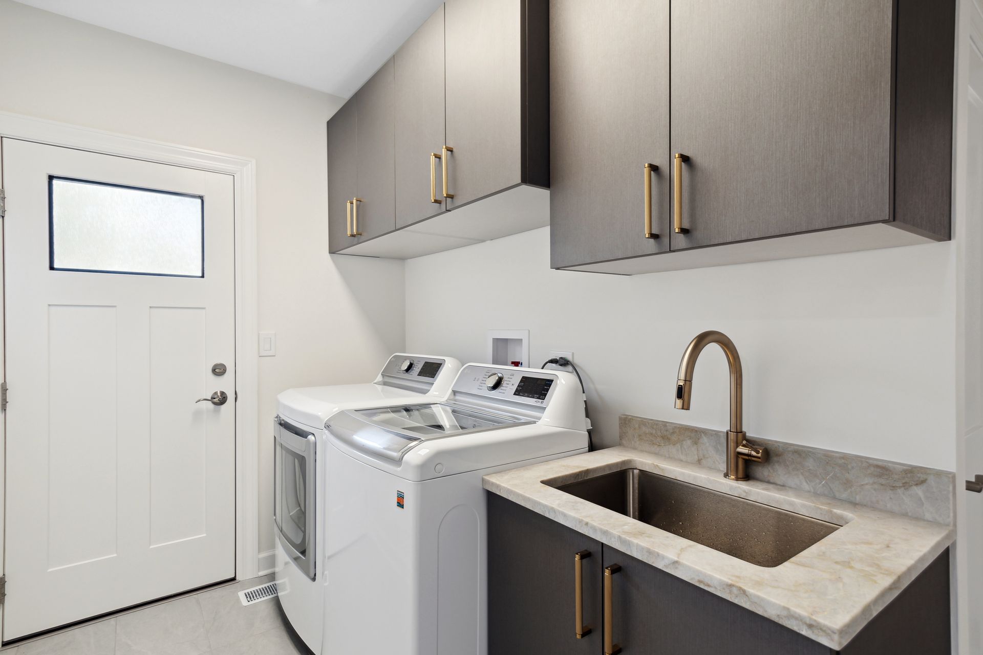 A laundry room with a washer and dryer and a sink.