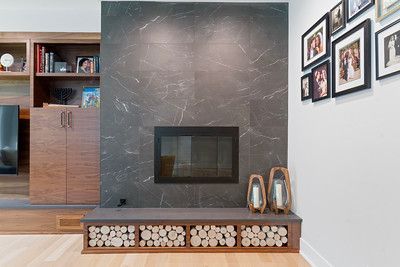 A living room with a fireplace and pictures on the wall.