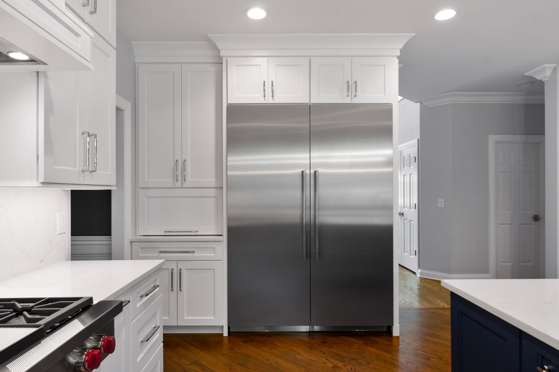 A kitchen with stainless steel appliances and white cabinets.