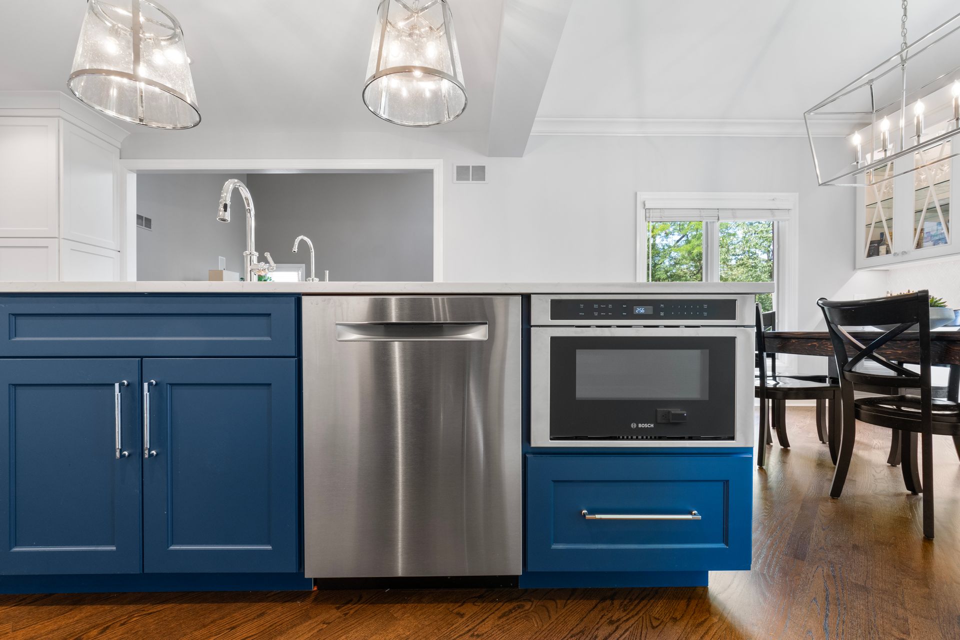 A kitchen with blue cabinets and stainless steel appliances.