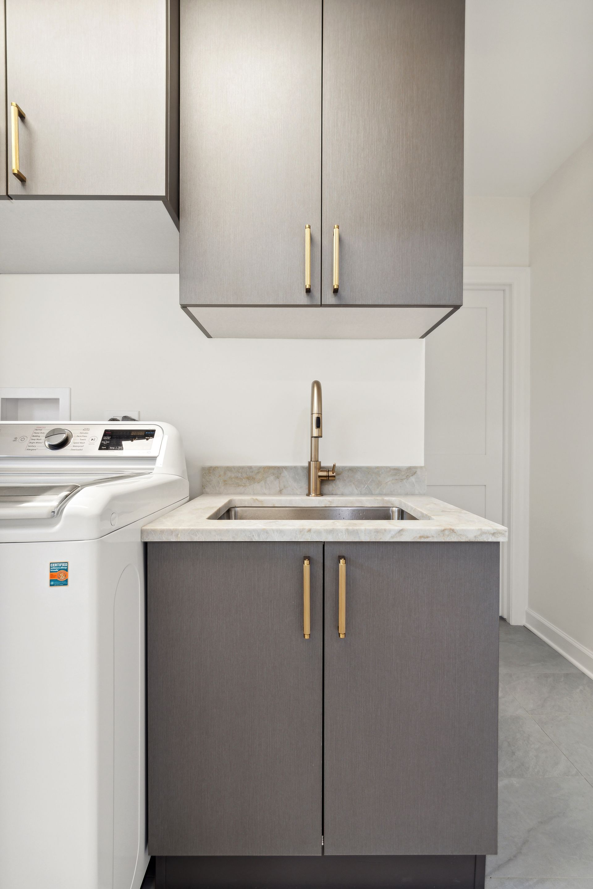 A laundry room with a washer and dryer and a sink.