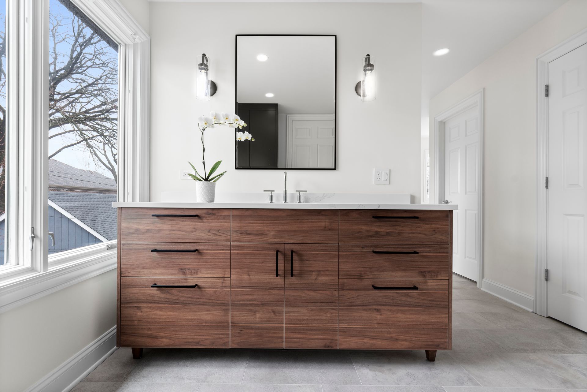 A bathroom with a large wooden vanity and a large mirror.