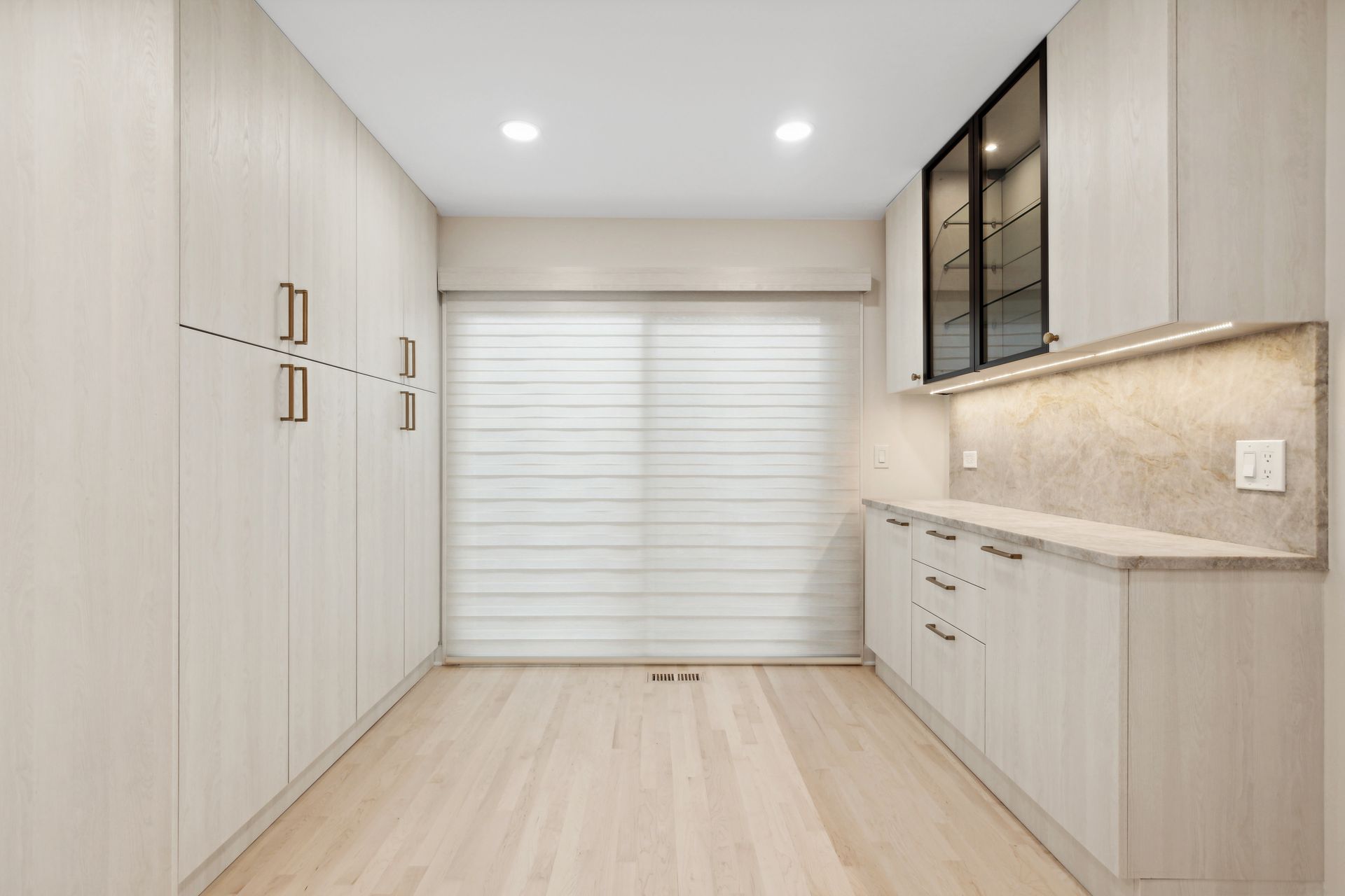 A room with a lot of cabinets and a sliding glass door.