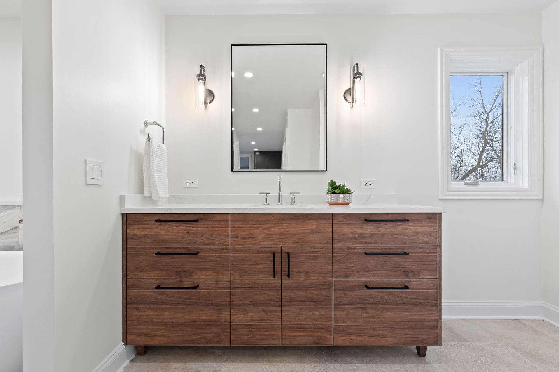 A bathroom with a large wooden vanity and a large mirror.