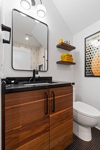 A bathroom with a sink , toilet and mirror.