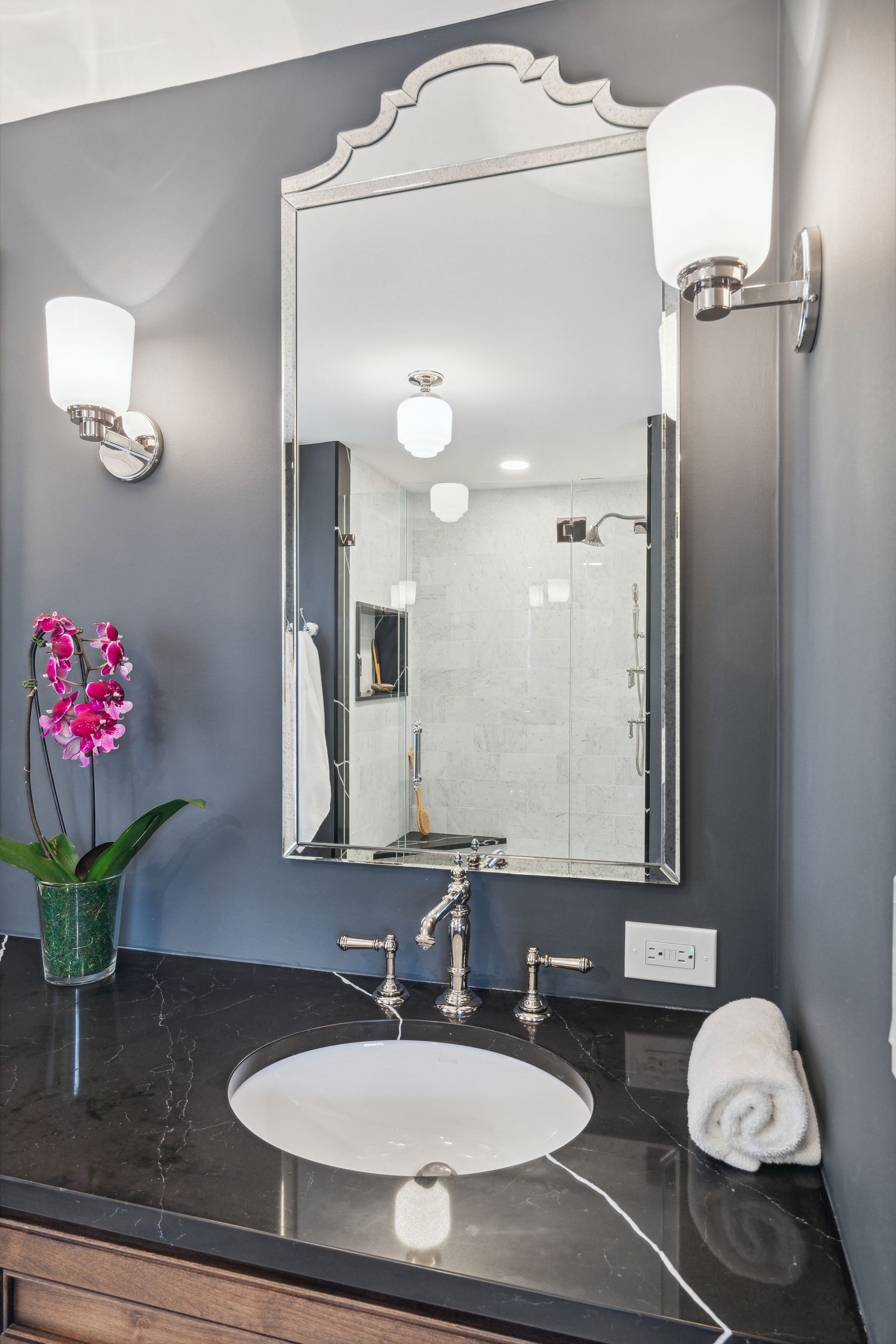 A bathroom with a sink , mirror and towels on the counter.