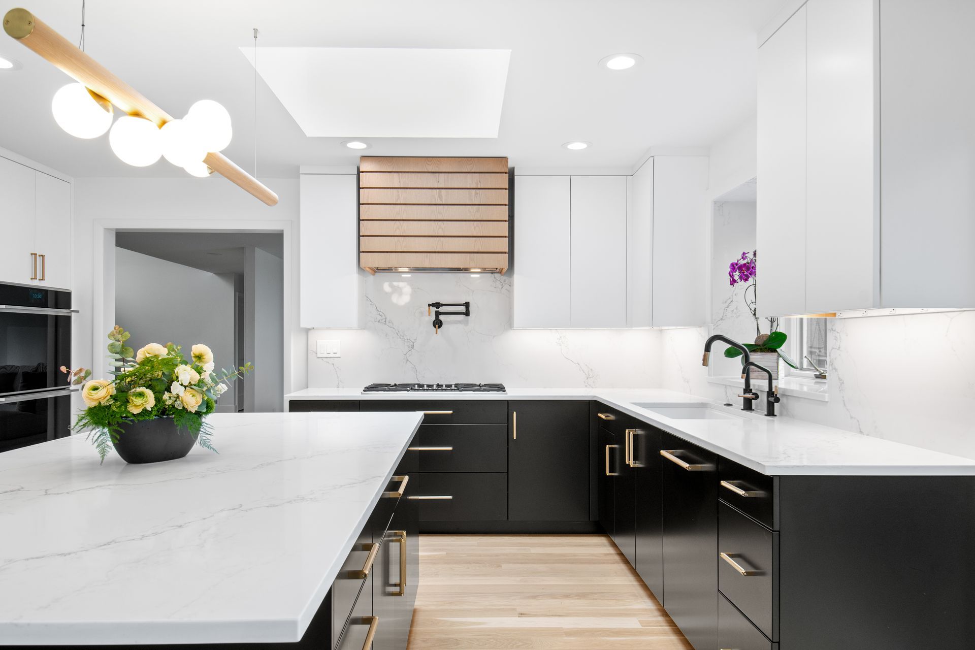 A kitchen with black cabinets and white counter tops.