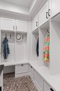 A mud room with white cabinets and a bench.