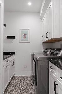 A laundry room with a washer and dryer and a picture on the wall.