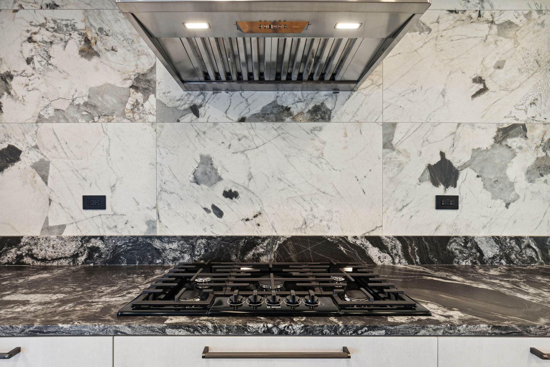 A kitchen with a stove top oven and a hood above it