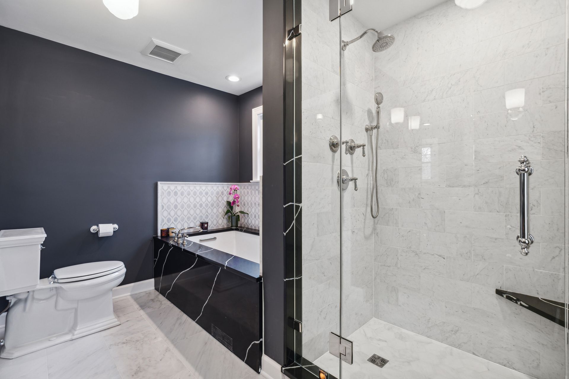 A bathroom with a toilet , tub and shower.