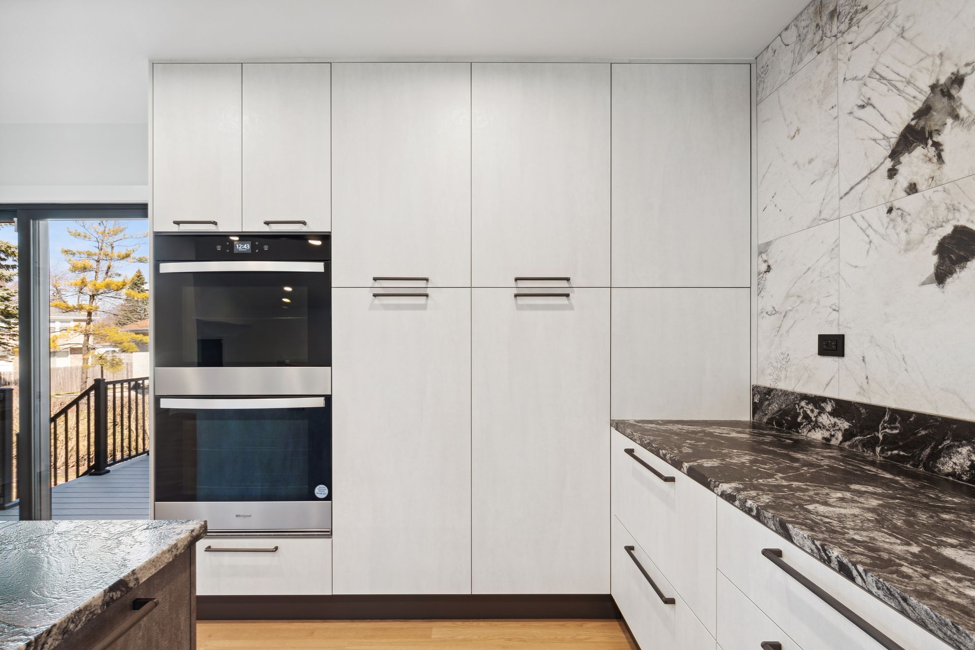 A kitchen with white cabinets , stainless steel appliances and granite counter tops.