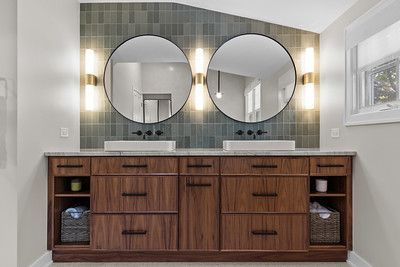 A bathroom with two sinks and two mirrors.
