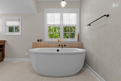 A bathroom with a bathtub and a window.