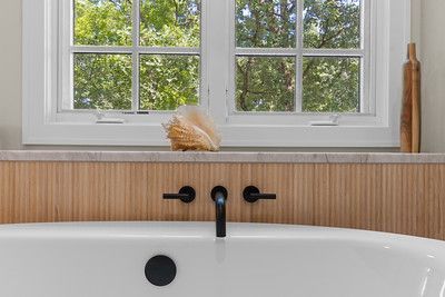 A bathroom with a bathtub and a window.