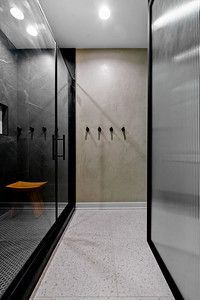 A hallway leading to a bathroom with a shower and a bench.