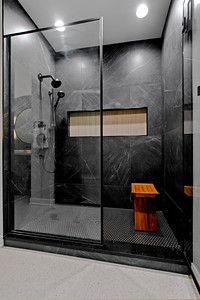 A bathroom with a walk in shower and a bench.