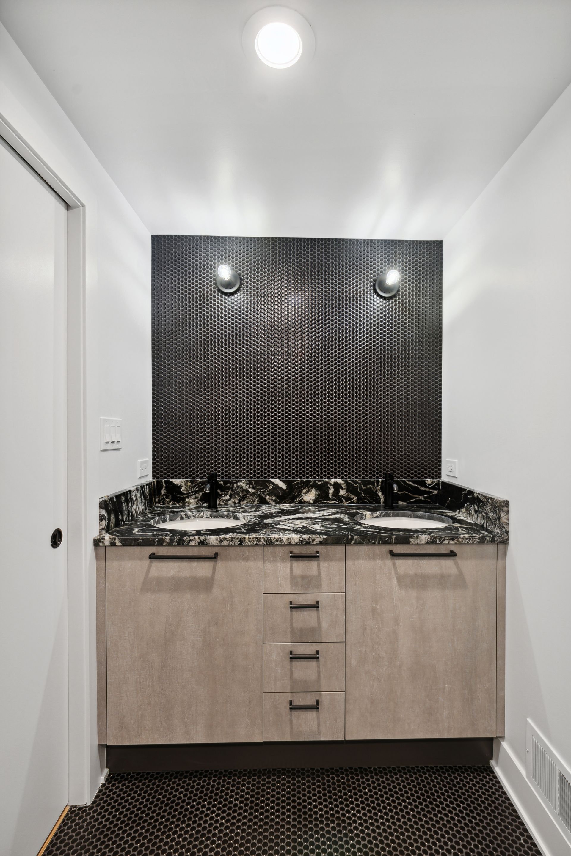 A bathroom with two sinks and a marble counter top.