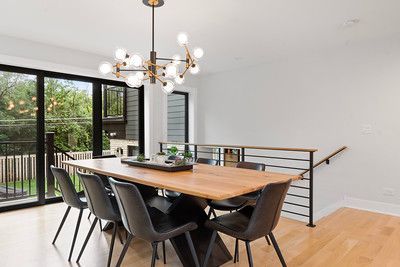 A dining room with a wooden table and chairs and a chandelier.