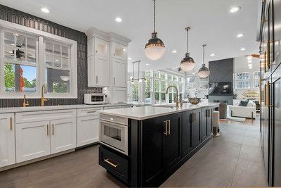 A kitchen with black and white cabinets and a large island.