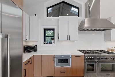 A kitchen with stainless steel appliances and wooden cabinets.