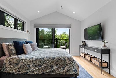 A bedroom with a large bed and a flat screen tv.